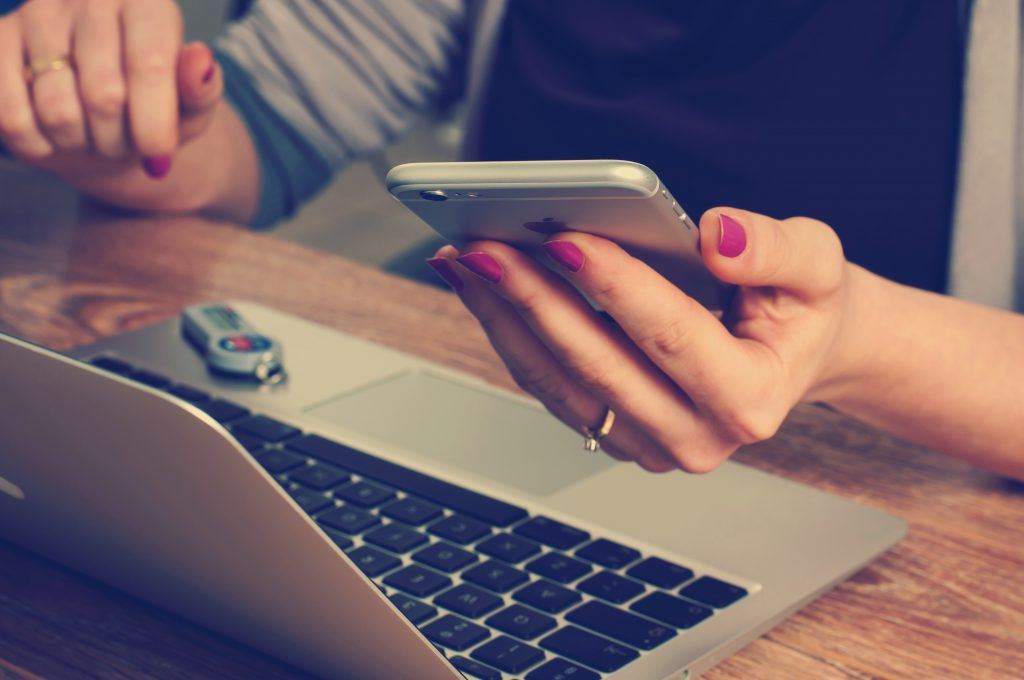 Businesswoman Working on laptop whilst holding phone